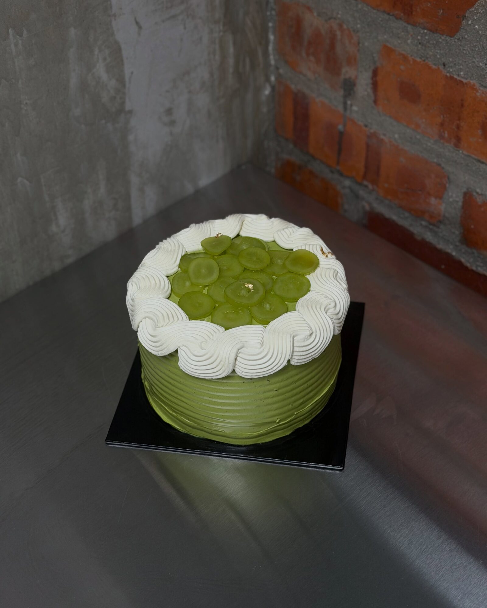 Matcha Jasmine Grape Cake on a black cake board